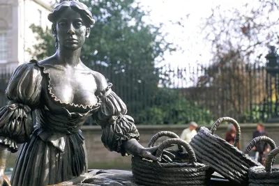 Bronze statue of Molly Malone with her cart of wicker baskets on a Dublin street