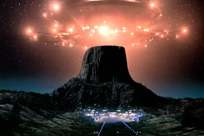 Film still from Close Encounters of the Third Kind: glowing mothership above Devils Tower at night