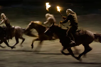 Film still from Django Unchained: hooded riders carrying torches gallop through the night