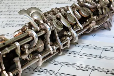 Close-up of a silver-keyed oboe lying on printed sheet music