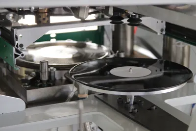 Freshly pressed black vinyl record on a record-pressing machine in a factory