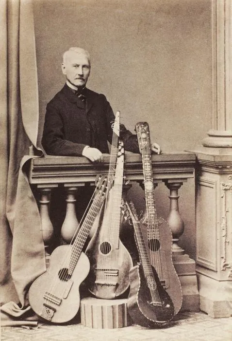 Sepia photo of Napoléon Coste standing behind a balustrade with several guitars