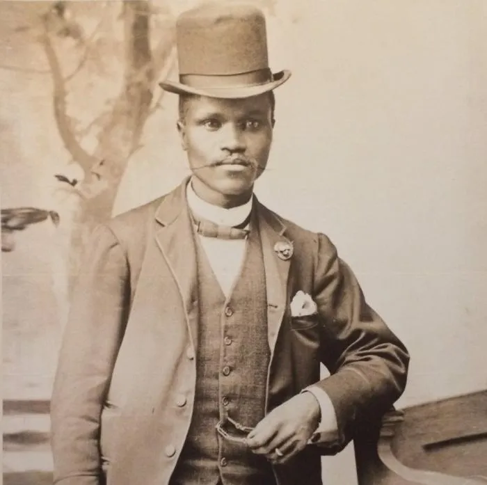 Sepia studio portrait of Enoch Sontonga in a top hat and three-piece suit