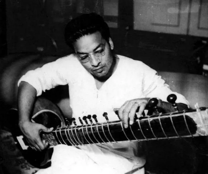 Black-and-white photo of Vilayat Khan in glasses playing the sitar