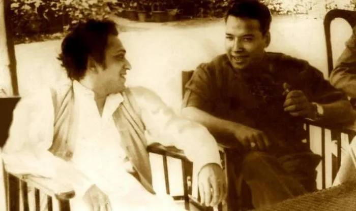 Sepia photo of Ravi Shankar and Vilayat Khan chatting in chairs on a veranda